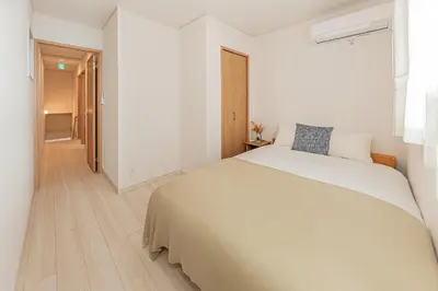 a white bedroom with a large bed and a hallway at Newly Built 4-Bedroom House in Shopping Street, 8-Min Walk from Akabane Station in Tokyo
