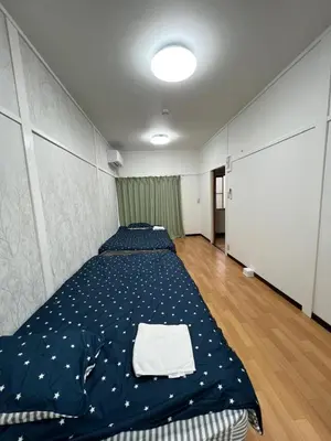 a bedroom with two beds with blue comforter at Core of Tokyo, 30 mins from Shinjuku & Ueno, LARGE in Tokyo