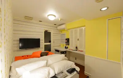a bedroom with a white couch and a television at Shibuya center-350m in Tokyo