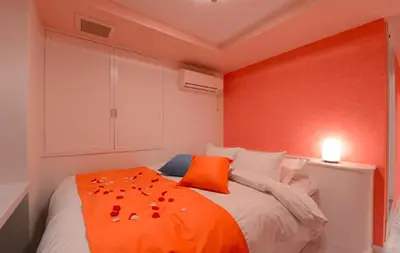 a bedroom with a bed with an orange blanket at Shibuya center-350m in Tokyo