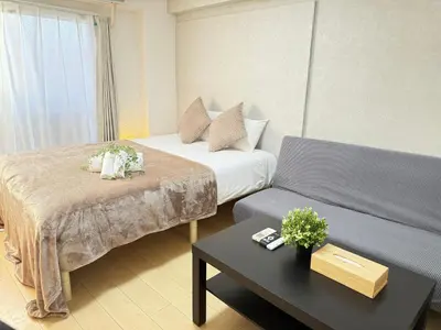 a hotel room with two beds and a couch at Shinjuku Area 41 Shinjuku Apartment in Tokyo