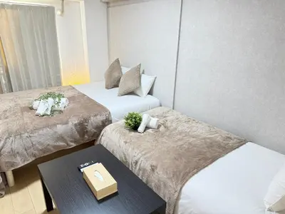 a hotel room with two beds and a table at Shinjuku Area 41 Shinjuku Apartment in Tokyo