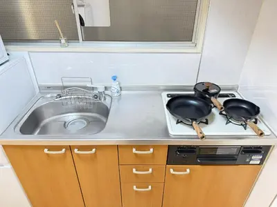 a kitchen with a sink and two pans on a stove at Shinjuku Area 41 Shinjuku Apartment in Tokyo