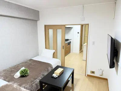 a bedroom with a bed and a table with a book on it at Shinjuku Area 41 Shinjuku Apartment in Tokyo
