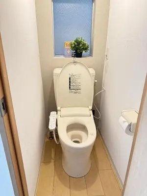 a bathroom with a toilet with a window and a plant at Shinjuku Area 41 Shinjuku Apartment in Tokyo
