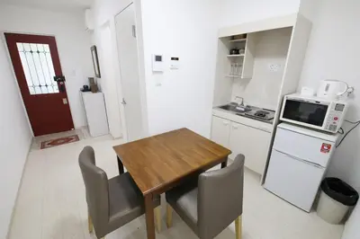 a small kitchen with a wooden table and chairs at Comore Villa 2F in Tokyo