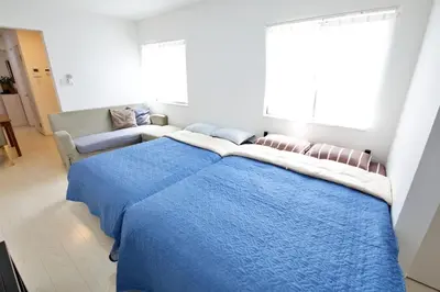 a bedroom with a large blue bed and a couch at Comore Villa 2F in Tokyo