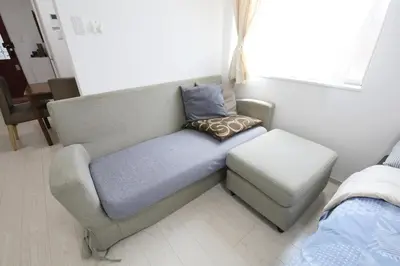 a couch and a stool in a room at Comore Villa 2F in Tokyo