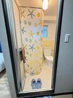 a bathroom with a toilet and blue shoes in it at Direct to Narita 9min walk from Kinshicho St Within walking distance of Asakusa and Skytree 50min bus ride to Disneyland 3min walk from the mall in Tokyo