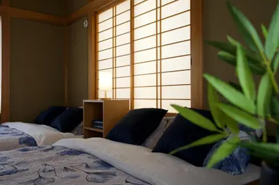 a bedroom with two beds and a potted plant at Peace House in Tokyo
