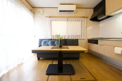 a living room with a table and a kitchen at Peace House in Tokyo