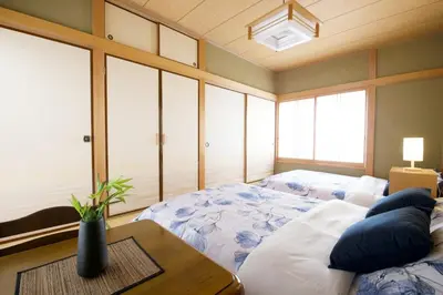 a bedroom with a large bed and a table at Peace House in Tokyo