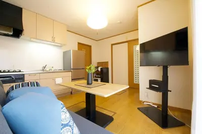 a living room with a couch and a table with a tv at Peace House in Tokyo