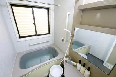 a small bathroom with a tub and a window at Peace House in Tokyo