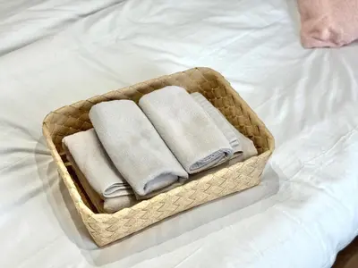 a basket with towels sitting on a bed at ShinjukuCityStay 502 in Tokyo