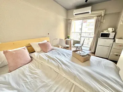 a bedroom with a large white bed with pink pillows at ShinjukuCityStay 502 in Tokyo