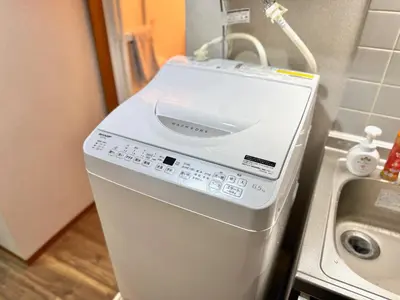 a washing machine sitting on a counter next to a sink at ShinjukuCityStay 502 in Tokyo