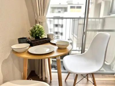 a table with two white bowls on it in a room with a window at ShinjukuCityStay 502 in Tokyo