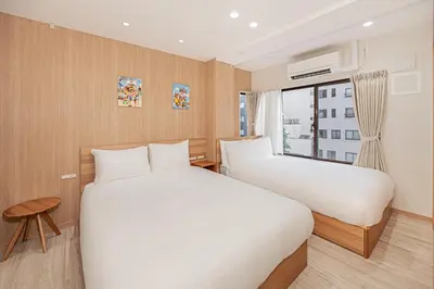 two beds in a room with a window at \u7b51\u4e0b\u65c5\u9928 \u4e0a\u91ce \u6d45\u8349 \u30b9\u30ab\u30a4\u30c4\u30ea\u30fc \u30a2\u30af\u30bb\u30b9\u826f\u597d \u5165\u8c37\u99c55\u5206 \u6700\u59274\u4eba in Tokyo