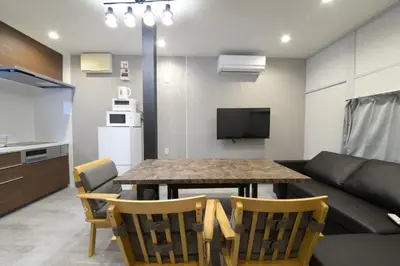 a living room with a table and a couch at \u548c\u306e\u6953Cottage\u7b2c\u4e8c \u65b0\u5bbf\u4e8c\u968e\u5efa\u30662\u5ba41\u30b7\u30e3\u30ef\u30fc1\u30c8\u30a4\u30ec in Tokyo