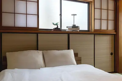 a bed with two pillows and a window in a room at 200 m2 Modern Japanese style private 6LDK House in Tokyo