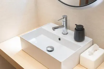 a bathroom sink with a black soap dispenser on it at 200 m2 Modern Japanese style private 6LDK House in Tokyo