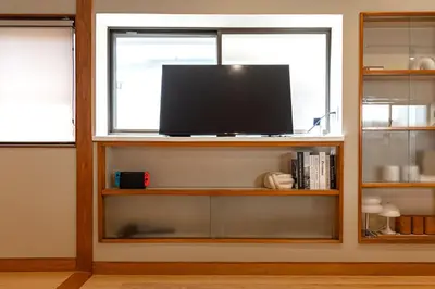 a flat screen tv on a shelf in a window at 200 m2 Modern Japanese style private 6LDK House in Tokyo
