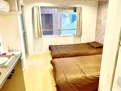 a small room with two beds and a window at Tokyo Meguro Bee House in Naka-Meguro in Tokyo