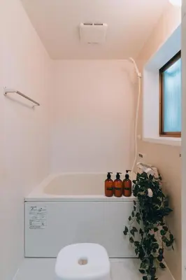 a bathroom with a toilet and a plant at Tokyo Nest Ohana in Tokyo