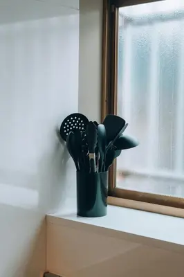 a container of kitchen utensils sitting on a window sill at Tokyo Nest Ohana in Tokyo