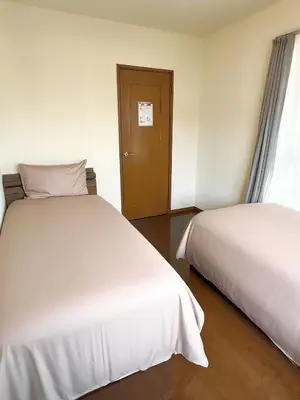 two beds in a hotel room with a door at \u30c7\u30a3\u30ba\u30cb\u30fc\u5f92\u6b69\u570f \u821e\u6d5c\u99c5\u5f92\u6b697\u5206 \u5927\u6b63\u6d6a\u6f2b\u304c\u606f\u3065\u304f\u4e0a\u8cea\u306a\u548c\u6d0b\u98a8\u8cb8\u5225\u8358 \u7a7a\u6e2f\u30a2\u30af\u30bb\u30b9\u826f\u597d \u559c\u697d\u5c4b in Tokyo