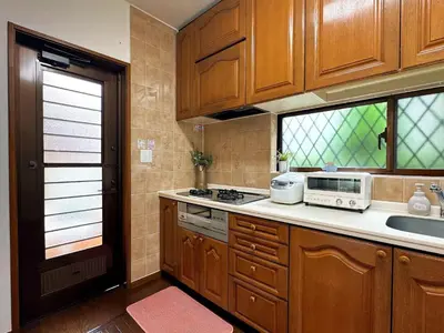 a kitchen with wooden cabinets and a sink and a microwave at \u30c7\u30a3\u30ba\u30cb\u30fc\u5f92\u6b69\u570f \u821e\u6d5c\u99c5\u5f92\u6b697\u5206 \u5927\u6b63\u6d6a\u6f2b\u304c\u606f\u3065\u304f\u4e0a\u8cea\u306a\u548c\u6d0b\u98a8\u8cb8\u5225\u8358 \u7a7a\u6e2f\u30a2\u30af\u30bb\u30b9\u826f\u597d \u559c\u697d\u5c4b in Tokyo