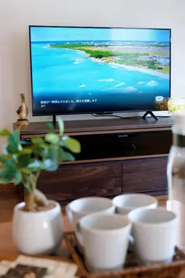 a group of white bowls on a table in front of a television at \u30c7\u30a3\u30ba\u30cb\u30fc\u5f92\u6b69\u570f \u821e\u6d5c\u99c5\u5f92\u6b697\u5206 \u5927\u6b63\u6d6a\u6f2b\u304c\u606f\u3065\u304f\u4e0a\u8cea\u306a\u548c\u6d0b\u98a8\u8cb8\u5225\u8358 \u7a7a\u6e2f\u30a2\u30af\u30bb\u30b9\u826f\u597d \u559c\u697d\u5c4b in Tokyo