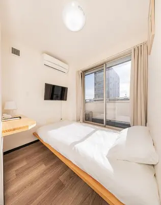 a bedroom with a large bed and a window at Louis stage showamachi in Tokyo