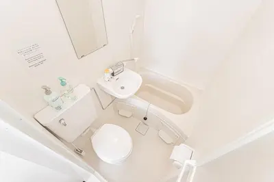 a white bathroom with a toilet and a sink at Louis stage showamachi in Tokyo