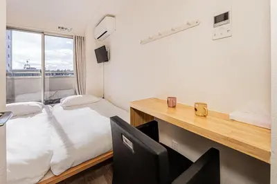 a room with a bed and a desk with a chair at Louis stage showamachi in Tokyo