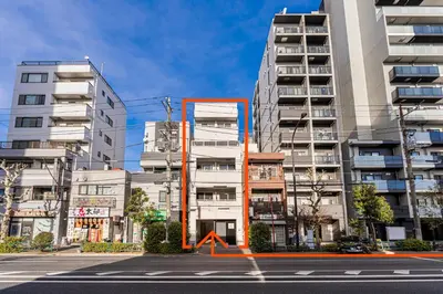 an empty city street with tall apartment buildings at Louis stage showamachi in Tokyo