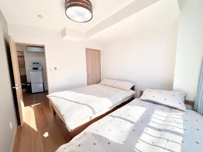 a bedroom with two beds and a refrigerator at 301, 6 min walk to subway stn, Tokyo Univ, Tokyo Tower, Tokyo-Dome direct by subway in Tokyo