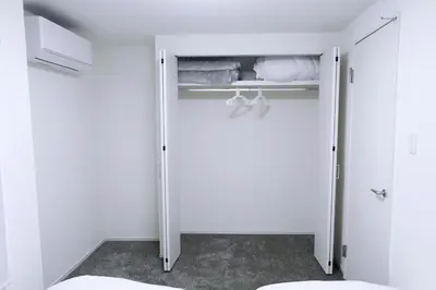 a bathroom with a closet with white walls and a toilet at Group Friendly - Prime 3BR - Great Location & Rooftop in Tokyo
