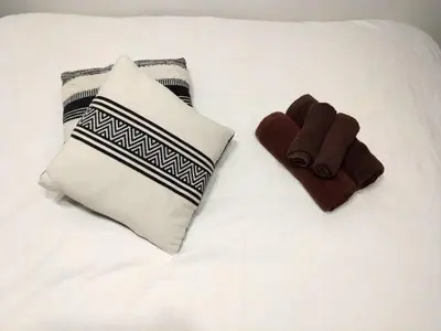 a white bed with two pillows and two towels at New open \u6e0b\u8c37\u99c5\u5f92\u6b695\u5206 \u90fd\u5fc3\u3078\u306e\u629c\u7fa4\u306e\u30a2\u30af\u30bb\u30b9 2\u540d\u307e\u3067\u5bbf\u6cca\u53ef\u80fd in Tokyo