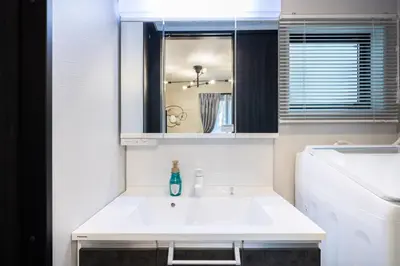 a bathroom with a white sink and a mirror at Bijou Suites Zephyr in Tokyo