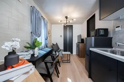 a kitchen with a sink and a table in a room at Bijou Suites Zephyr in Tokyo