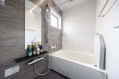 a bathroom with a shower and a white bathtub at Bijou Suites Zephyr in Tokyo