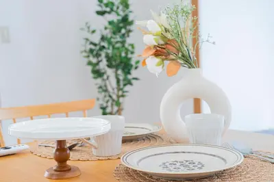 a table with plates and a vase with flowers at Tokyo Ikebukuro apartment near Pokemon Center in Wada