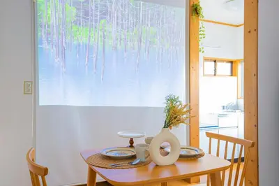 a dining room table with a vase on top of it at Tokyo Ikebukuro apartment near Pokemon Center in Wada