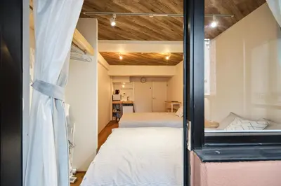 a bedroom with two beds and a mirror at \u65b0\u5bbf\u5e02\u4e2d\u5fc3\u6b4c\u821e\u4f0e\u807d\u8fd1\u4f0a\u52e2\u4e39\u6771\u65b0\u5bbf\u7ad9\u5f92\u6b653\u5206\u9418#11 in Tokyo