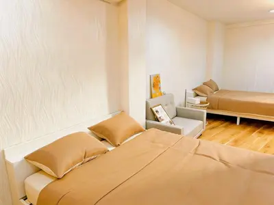 a bedroom with two beds and a couch and a chair at Opening in December ,Riverside stay,to Narita Airport ,Shinjuku in Tokyo
