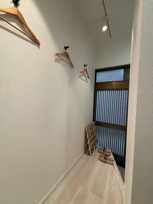 a hallway with hangers and shoes on the wall at APRO STAY\u7fbd\u7530 garden7 201\u53f7\u5ba4 in Tokyo