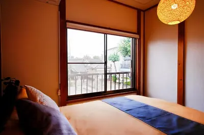 a bedroom with a bed and a large window at Takara Entire Japanese house with a view of the shrine in Tokyo