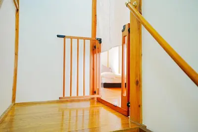 a stairway with a wooden railing and a room with a bed at Takara Entire Japanese house with a view of the shrine in Tokyo